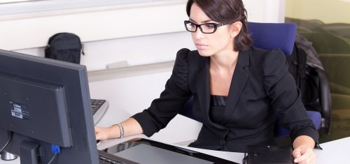 Photo d'une secrétaire travaillant sur un logiciel de Paye et RH