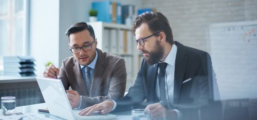 Photo de deux personnes utilisant des logiciels de reporting